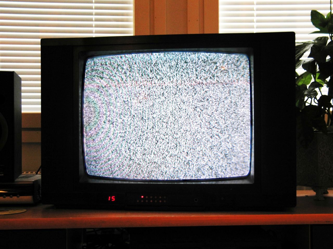 An old cathode-ray television showing grey static on an empty channel.