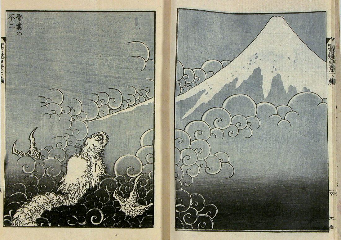 Woodblock print of a dragon rising through swirling clouds on the left page, with snow-capped Mount Fuji on the right page.